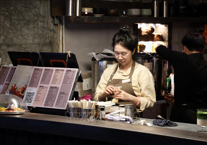 Nhân viên bán hàng làm việc bán thời gian trong một quán cà phê ở phường Gia Định, Thành phố Hồ Chí Minh. Ảnh: Hồng Đạt - TTXVN