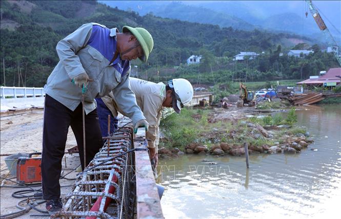 Công nhân hối hả thi công lan can cầu An Lương, xã Mỏ Vàng (Yên Bãi cũ). Ảnh: Quốc Khánh - TTXVN