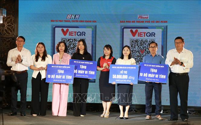 Lãnh đạo tỉnh Khánh Hòa cùng ban tổ chức chương trình trao bảng tượng trưng hỗ trợ kinh phí cho các trường bị thiệt hại nặng nề trong đợt mưa lũ. Ảnh Phan Sáu - TTXVN