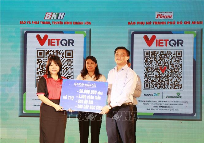 Đại diện các đơn vị, doanh nghiệp trao bảng tượng trưng kinh phí ủng hộ chương trình tặng sách cho học sinh vùng lũ. Ảnh Phan Sáu - TTXVN