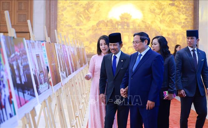 Thủ tướng Phạm Minh Chính và Quốc vương Brunei Darussalam Haji Hassanal Bolkiah tham quan trưng bày ảnh về quan hệ hợp tác giữa hai nước, do Thông tấn xã Việt Nam thực hiện. Ảnh: Dương Giang-TTXVN