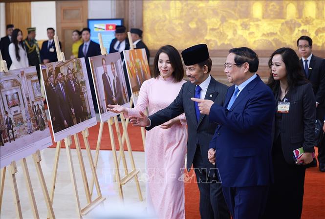 Thủ tướng Phạm Minh Chính và Quốc vương Brunei Darussalam Haji Hassanal Bolkiah tham quan trưng bày ảnh về quan hệ hợp tác giữa hai nước, do Thông tấn xã Việt Nam thực hiện. Ảnh: Dương Giang-TTXVN