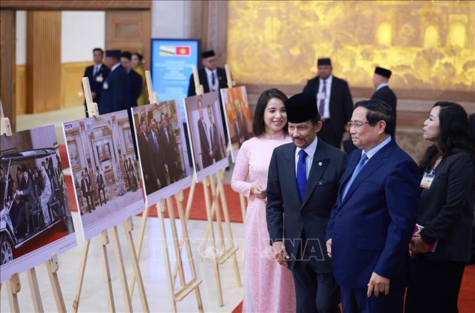 Thủ tướng Phạm Minh Chính và Quốc vương Brunei Darussalam Haji Hassanal Bolkiah tham quan trưng bày ảnh về quan hệ hợp tác giữa hai nước, do Thông tấn xã Việt Nam thực hiện. Ảnh: Dương Giang-TTXVN