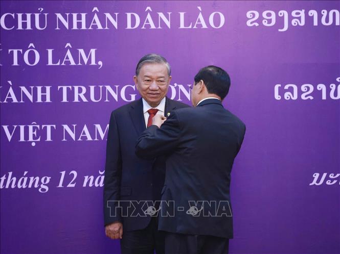 Tổng Bí thư, Chủ tịch nước Lào Thongloun Sisoulith trao tặng Huân chương Vàng Quốc gia của Nhà nước Lào cho Tổng Bí thư Tô Lâm. Ảnh: Thống Nhất - TTXVN
