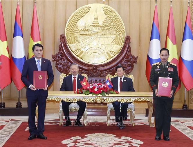 Tổng Bí thư Tô Lâm và Tổng Bí thư, Chủ tịch nước Lào Thongloun Sisoulith chứng kiến trao Biên bản ghi nhớ giữa Bộ Công an Việt Nam và Bộ Quốc phòng Lào về dự án xây dựng tuyến đường hữu nghị Việt Nam - Lào. Ảnh: Thống Nhất - TTXVN 
