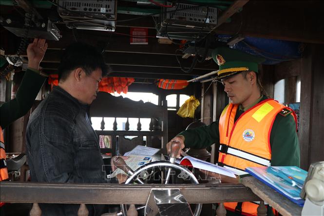 Kiểm tra, kiểm soát các giấy tờ, hồ sơ thủ tục của tàu cá trước khi xuất bến. Ảnh: Mai Trang - TTXVN