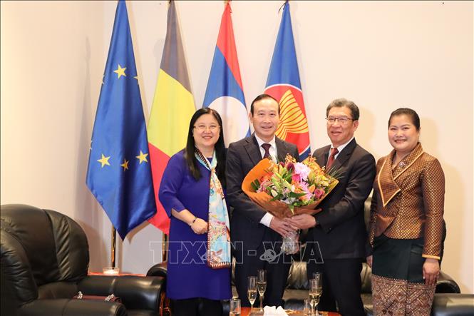 Đại sứ Nguyễn Văn Thảo và phu nhân tặng hoa chúc mừng Đại sứ Lào Kingphokeo Phommahaxay và phu nhân. Ảnh : Hương Giang - PV TTXVN tại Bỉ