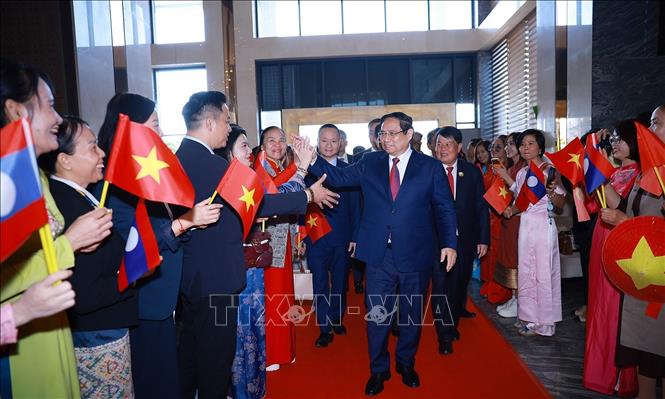 Cán bộ, nhân viên Đại sứ quán và cộng đồng người Việt Nam tại Lào đón Thủ tướng Phạm Minh Chính đến Thủ đô Vientiane đồng chủ trì Kỳ họp lần thứ 48 Ủy ban liên Chính phủ Việt Nam-Lào. Ảnh: Dương Giang-TTXVN 
