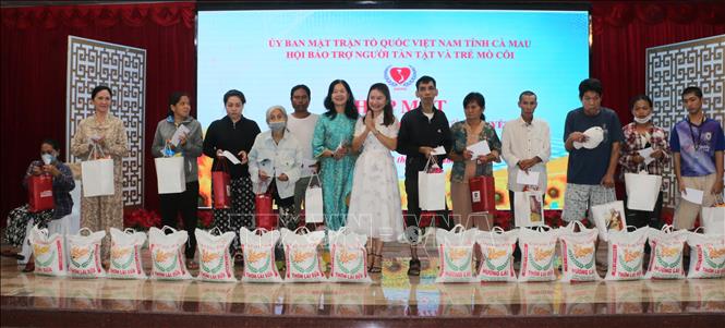Lãnh đạo Hội Bảo trợ người tàn tật và trẻ mồ côi tỉnh Cà Mau cùng nhà hảo tâm trao quà cho người khuyết tật. Ảnh: Tuấn Kiệt – TTXVN