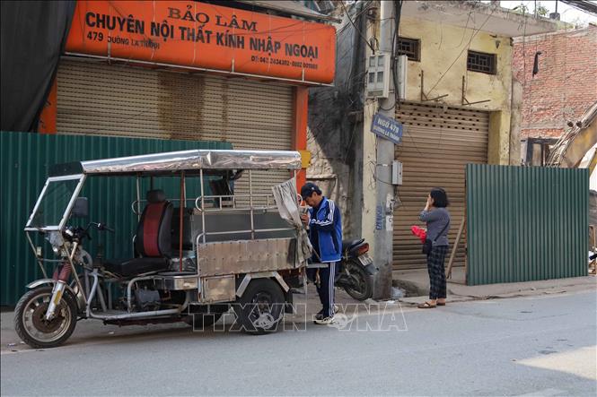 Người dân di chuyển đồ đạc để bàn giao mặt bằng thực hiện dự án xây dựng đường Vành đai 1 đoạn Hoàng Cầu - Voi Phục. Ảnh: Nguyễn Thắng - TTXVN