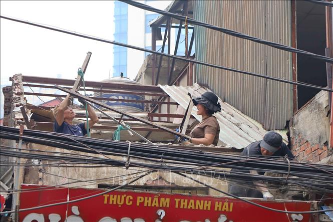 Người dân khẩn trương tháo dỡ nhà để bàn giao mặt bằng sạch để thực hiện dự án xây dựng đường Vành đai 1 đoạn Hoàng Cầu - Voi Phục. Ảnh: Nguyễn Thắng - TTXVN