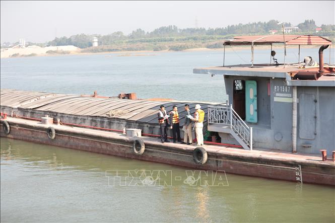 Lực lượng chức năng liên ngành kiểm tra hành chính phương tiện đường thủy tại cảng nội địa của Công ty TNHH thương mại và dịch vụ Ánh Nhật. Ảnh: Tạ Toàn – TTXVN