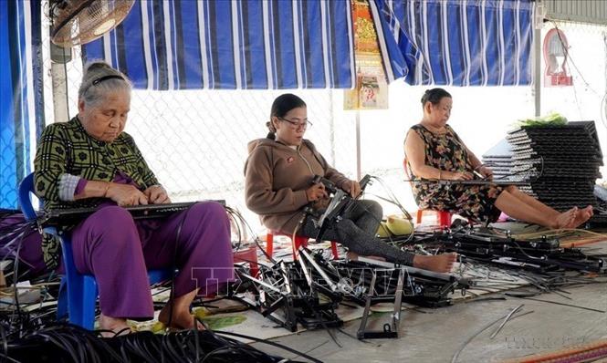 Chị Võ Thị Diễm (giữa) là một người khuyết tật ở phường Nhơn Bình, thành phố Quy Nhơn (Bình Định) đã nỗ lực vượt hoàn cảnh và mặc cảm để phát triển kinh tế. Chị đã đầu tư cơ sở gia công mây đan xuất khẩu với doanh thu đạt gần 1 tỷ đồng/năm, giải quyết việc làm cho hơn 20 lao động địa phương (là người khuyết tật, người cao tuổi) có thu nhập từ 3,5 - 4 triệu đồng/người/tháng. Ảnh: Lê Phước Ngọc- TTXVN 