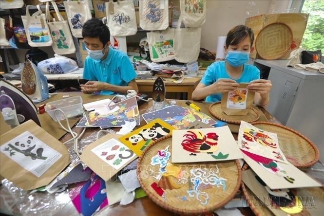 Nguồn nguyên liệu vải thừa đã được “thổi hồn” thành những sản phẩm độc đáo, qua đôi bàn tay của những người lao động khuyết tật ở Hợp tác xã Vụn Art (Hà Đông, Hà Nội): Ảnh: Minh Quyết - TTXVN