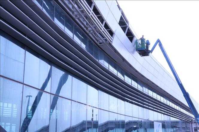 Nhân viên kỹ thuật hoàn thiện vách kính nhà ga hành khách sân bay Long Thành. Ảnh: Công Phong - TTXVN