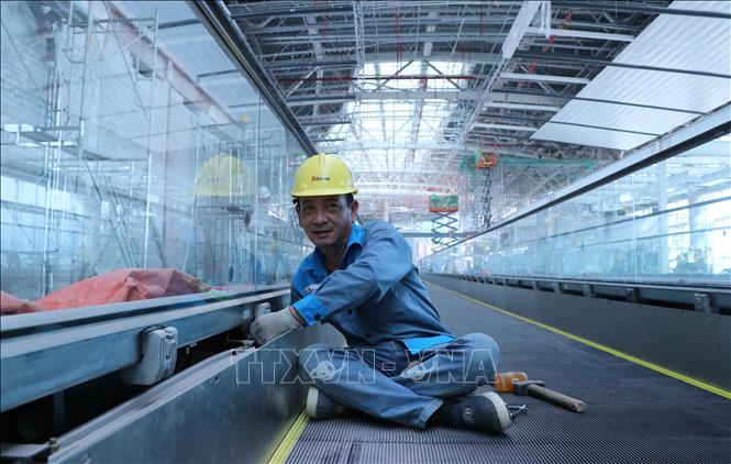 Nhân viên kỹ thuật  hoàn thiện cầu thang bộ hành nhà ga hành khách sân bay Long Thành. Ảnh: Công Phong - TTXVN