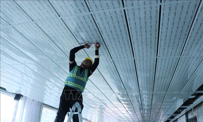 Nhân viên kỹ thuật  hoàn thiện trần tầng 1 nhà ga hành khách sân bay Long Thành. Ảnh: Công Phong - TTXVN