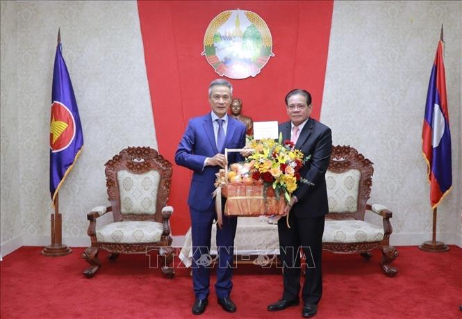 Đại sứ Việt Nam tại Campuchia Nguyễn Minh Vũ chúc mừng Đại sứ Lào tại Campuchia Buakeo Phumvongsay nhân dịp kỷ niệm 50 năm Quốc khánh Lào. Ảnh: TTXVN phát