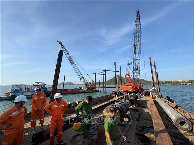 Công ty Điện lực An Giang phối hợp với lực lượng chức năng chuẩn bị dựng trụ, xây dựng đường dây tạm trên không để cấp điện cho Phú Quốc. Ảnh: TTXVN phát