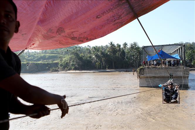 Người dân tìm cách qua sông bằng hệ thống dây kéo khi cây cầu bị phá huỷ do mưa lũ tại tỉnh Aceh, Indonesia ngày 1/12/2025. Ảnh: THX/TTXVN