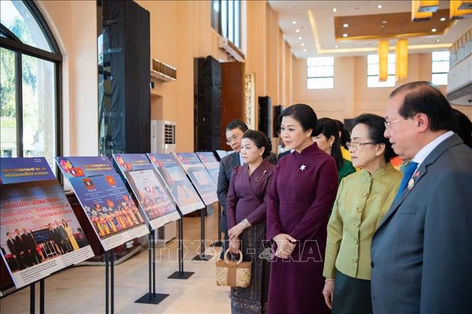 Madame Ngo Phuong Ly, wife of Party General Secretary To Lam, and Madame Naly Sisoulith, wife of Party General Secretary and President of Laos Thongloun Sisoulith tour a photo exhibition on the great friendship between Vietnam and Laos. VNA Photo/Photo by courtesy