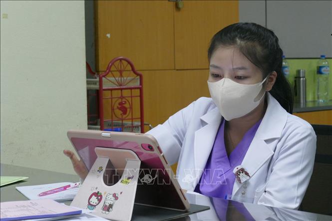 Cán bộ y tế kiểm tra lịch đặt khám của bệnh nhân. Ảnh: Xuân Tú - PV TTXVN tại Lào