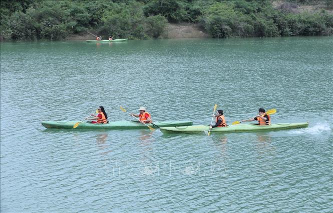 Du khách trải nghiệp chèo SUP hồ Nong Dùng tại Khu cắm trại Michi Camp. Ảnh: Anh Tuấn – TTXVN