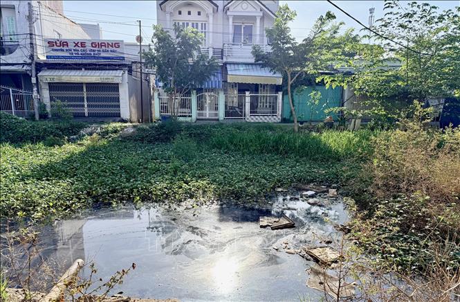 Rạch Bà Bầu tồn đọng bùn và rác thải do dự án chỉnh trang kéo dài nhiều năm chưa hoàn thiện. Ảnh: Thanh Sang-TTXVN