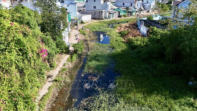 Rạch Bà Bầu tồn đọng bùn và rác thải gây ô nhiễm nghiêm trọng do dự án chỉnh trang kéo dài nhiều năm chưa hoàn thiện. Ảnh: Thanh Sang-TTXVN