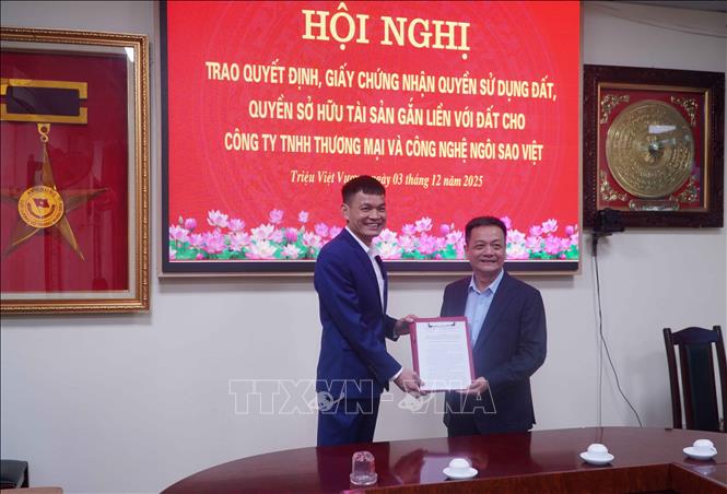 Lãnh đạo UBND xã Triệu Việt Vương trao Quyết định, Giấy chứng nhận quyền sử dụng đất, quyền sở hữu tài sản gắn liền với đất cho Công ty TNHH thương mại và công nghệ Ngôi Sao Việt. Ảnh: Nguyễn Công Hải - TTXVN