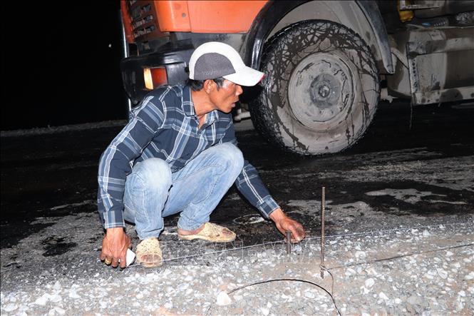 Công nhân đo đạc để thi công thảm bê tông nhựa trên công trường cao tốc Cần Thơ - Cà Mau. Ảnh: Tuấn Phi - TTXVN