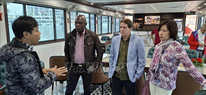 Đoàn nghe giới thiệu về vịnh Hạ Long trên tàu tham quan vịnh. Ảnh: Đức Hiếu - TTXVN