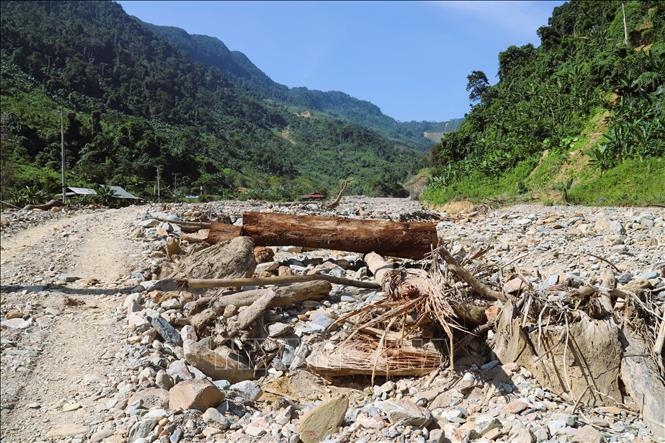 Khu vực trung tâm bản Phá Mựt hiện chỉ còn khung cảnh ngổn ngang đá, thân cây và rác. Ảnh: Xuân Tiến - TTXVN 