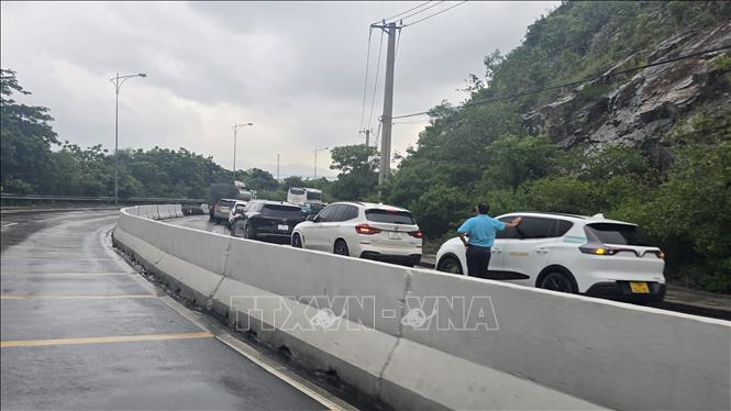 Xe tải chờ hành khách đi sân bay Cam Ranh ách tắc nối dài do vụ lật xe. Ảnh: Phan Sáu - TTXVN