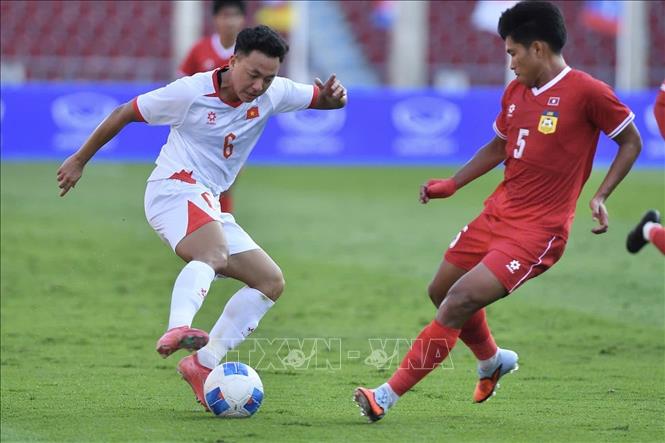 Pha tranh bóng giữa Thái Sơn và cầu thủ bên phía U22 Lào. Ảnh: TTXVN