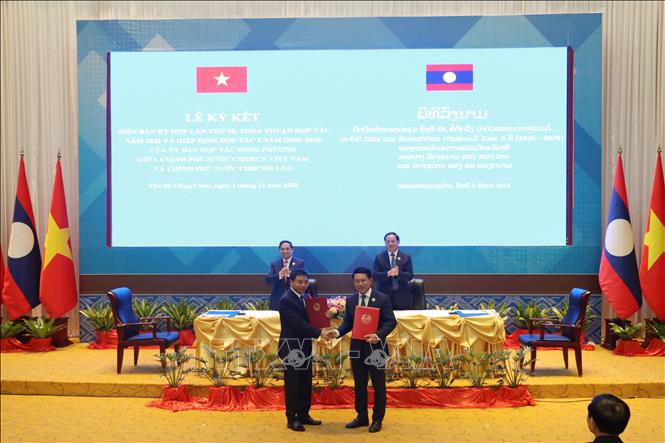 Chủ tịch Ủy ban hợp tác Việt Nam - Lào Nguyễn Văn Thắng và Chủ tịch Ủy ban hợp tác Lào - Việt Nam Saleumxay Kommasith trao đổi văn kiện hợp tác đã ký kết. Ảnh: Xuân Tú - PV TTXVN tại Lào