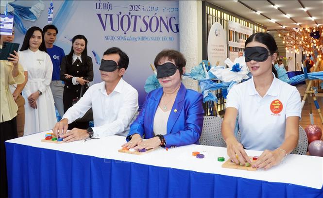 Đại biểu tham gia trò chơi để thấu hiểu hơn với người khiếm thị gặp phải. Ảnh: Trung Tuyến – TTXVN