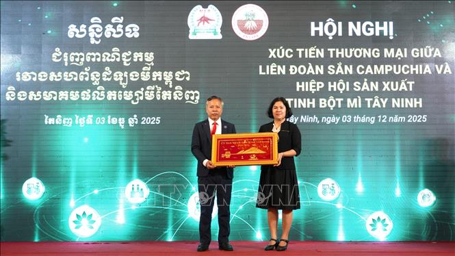 Bà Châu Thị Lệ - Phó Giám đốc Sở Công thương tỉnh Tây Ninh tặng quà hữu nghị cho ông Reach Ra Quốc vụ khanh Bộ Thương mại Vương quốc Campuchia. Ảnh: Minh Phú – TTXVN