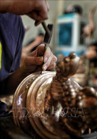 Nghề gò, đúc đồng đòi hỏi thao tác rất tỉ mỉ. Ảnh: Danh Lam-TTXVN