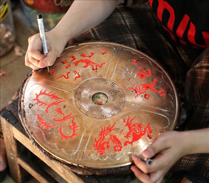 Nghề gò, đúc đồng đòi hỏi thao tác rất tỉ mỉ. Ảnh: Danh Lam-TTXVN