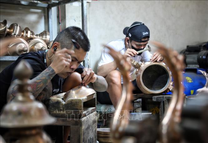 Nghề gò, đúc đồng đòi hỏi thao tác rất tỉ mỉ. Ảnh: Danh Lam-TTXVN