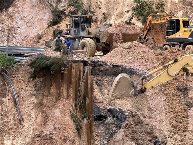 Các phương tiện của Công ty TNHH Hưng Nguyên nỗ lực xử lý khu vực sạt lở nhằm thông đèo Mimosa vào chiều 4/12. Ảnh: Chu Quốc Hùng- TTXVN