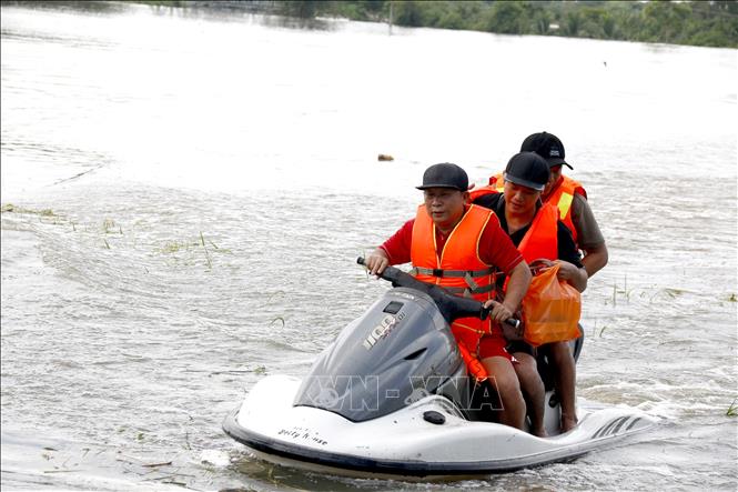 Lực lượng tình nguyện viên hỗ trợ di dời khẩn cấp người dân bị ngập đến nơi an toàn. Ảnh: Nguyễn Thanh - TTXVN