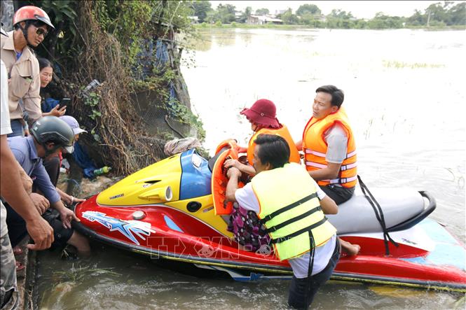 Lực lượng tình nguyện viên hỗ trợ di dời khẩn cấp người dân bị ngập đến nơi an toàn. Ảnh: Nguyễn Thanh - TTXVN