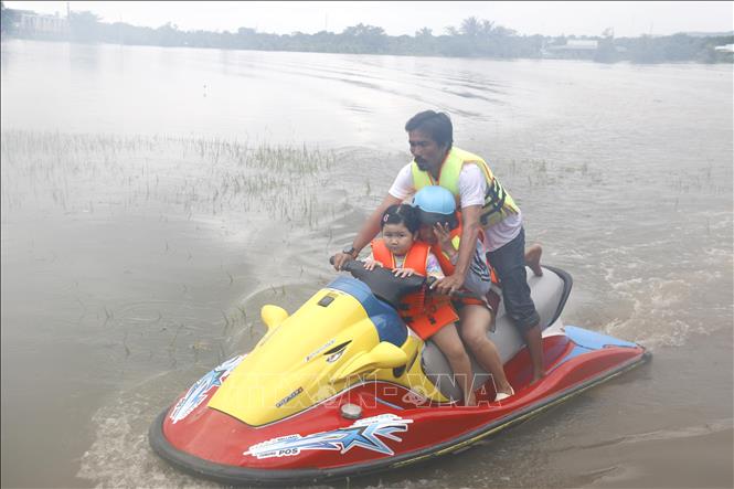 Lực lượng tình nguyện viên hỗ trợ di dời khẩn cấp người dân bị ngập đến nơi an toàn. Ảnh: Nguyễn Thanh - TTXVN