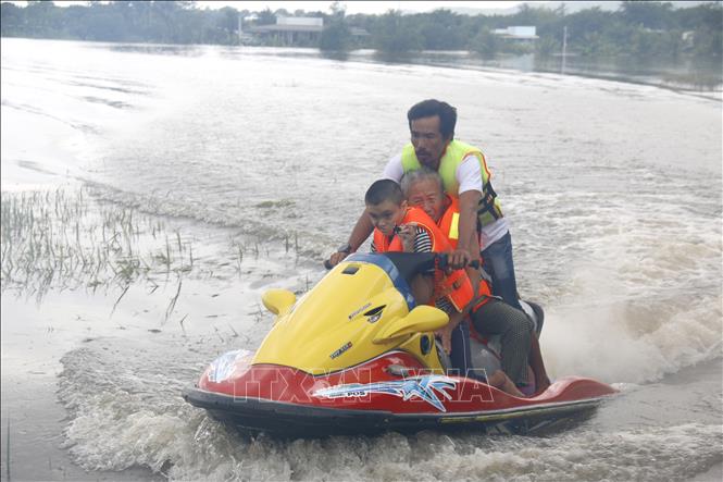Lực lượng tình nguyện viên hỗ trợ di dời khẩn cấp người dân bị ngập đến nơi an toàn. Ảnh: Nguyễn Thanh - TTXVN