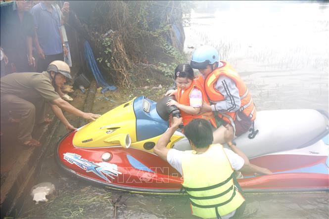 Lực lượng tình nguyện viên hỗ trợ di dời khẩn cấp người dân bị ngập đến nơi an toàn. Ảnh: Nguyễn Thanh - TTXVN