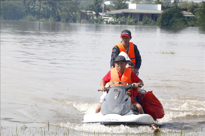 Lực lượng tình nguyện viên hỗ trợ di dời khẩn cấp người dân bị ngập đến nơi an toàn. Ảnh: Nguyễn Thanh - TTXVN
