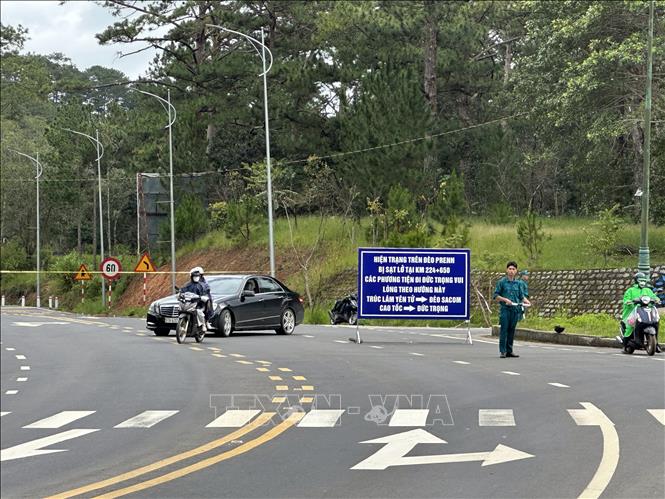 Lực lượng chức năng hướng dẫn các phương tiện di chuyển theo hướng đèo Sacom. Ảnh: Chu Quốc Hùng-TTXVN