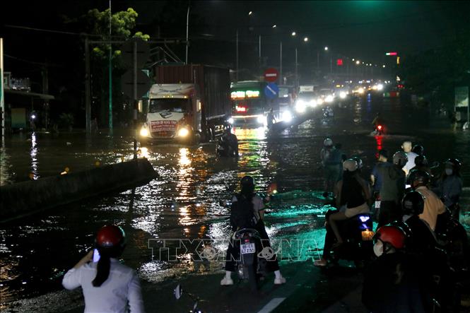 Quốc lộ 1A, đoạn qua phường Hàm Thắng (Lâm Đồng) bị ngập sâu, các phương tiện lưu thông khó khăn. Ảnh: Nguyễn Thanh - TTXVN